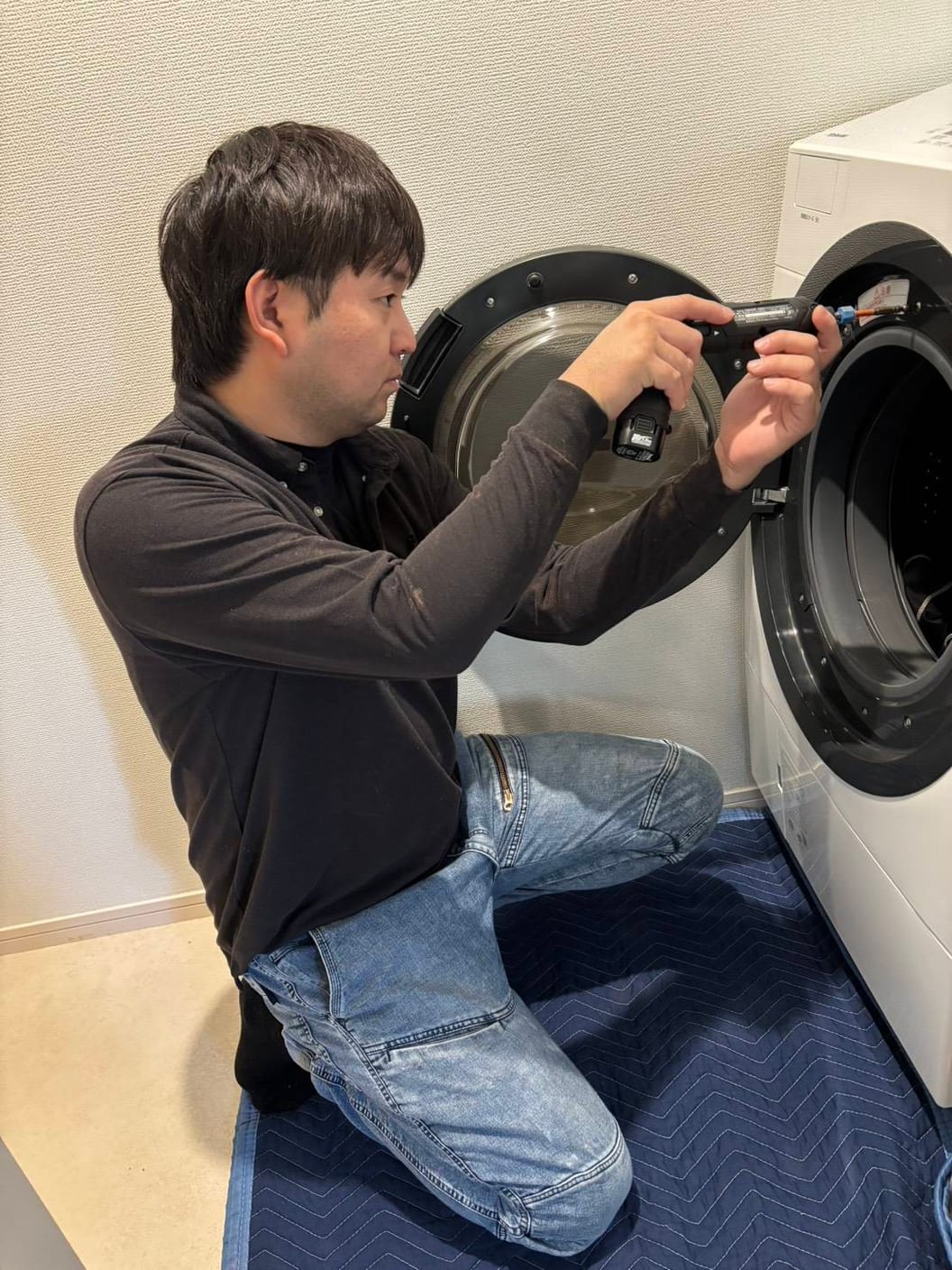 ドラム式洗濯機を分解する代表の八鍬 和弘